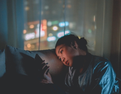 person looking at their phone in the dark