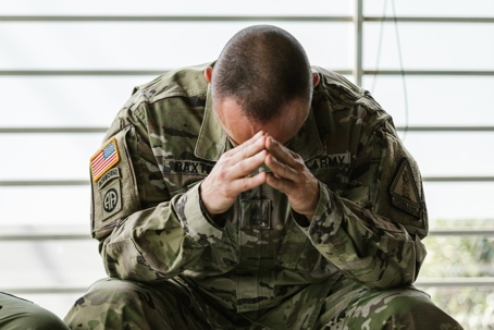 military man with head in his hands