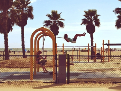 playground by the beach with kids swinging on the playset