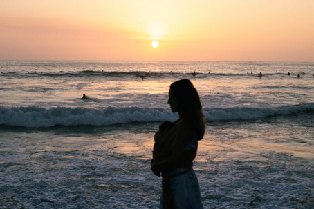 Mom Walking with Baby on Beach at Sunset